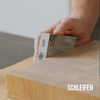 Schneidebrett mit dem Schleifschwamm glätten
